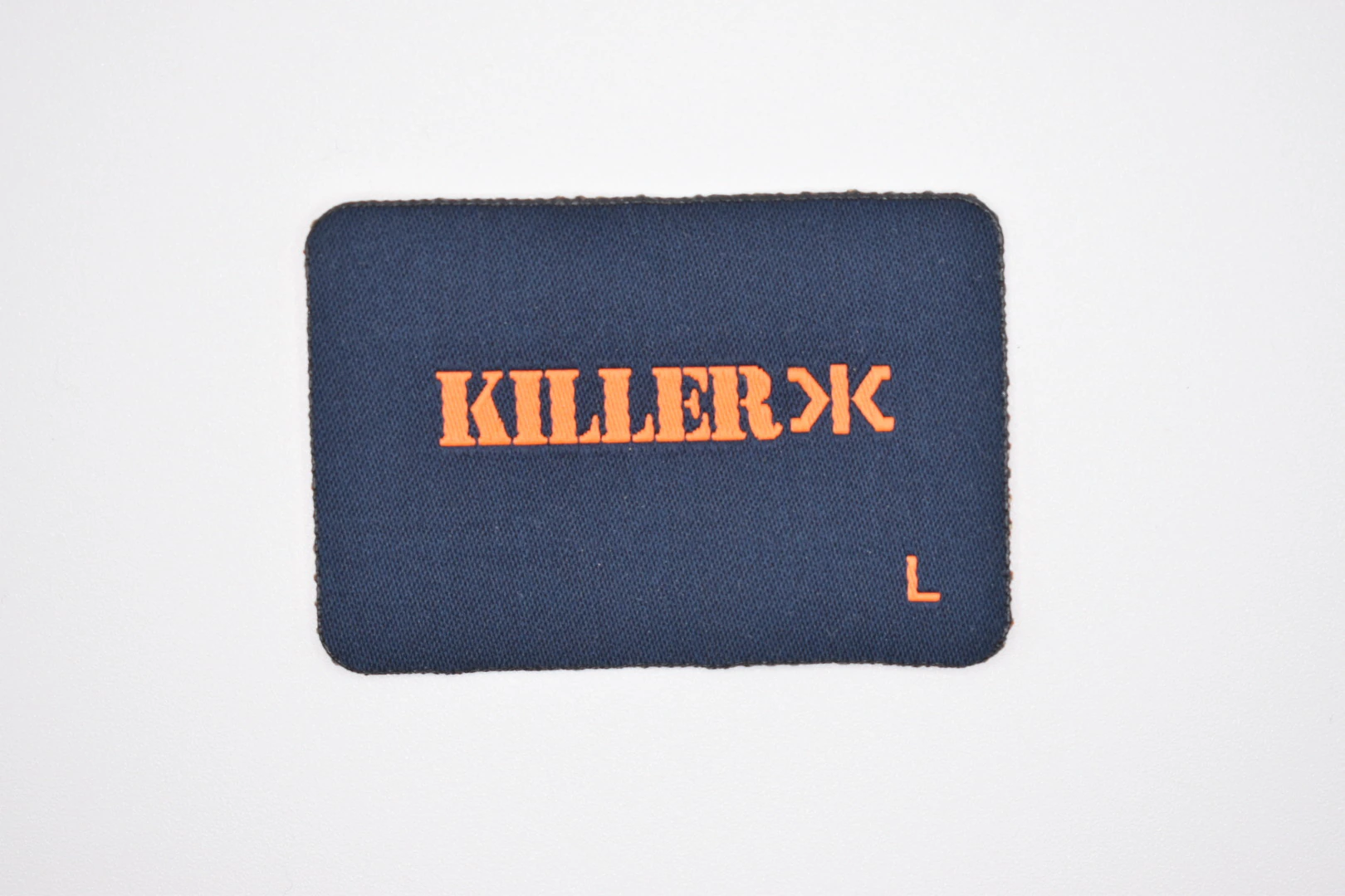 Killerx die-cut woven brand label — front view, custom clothing label sample