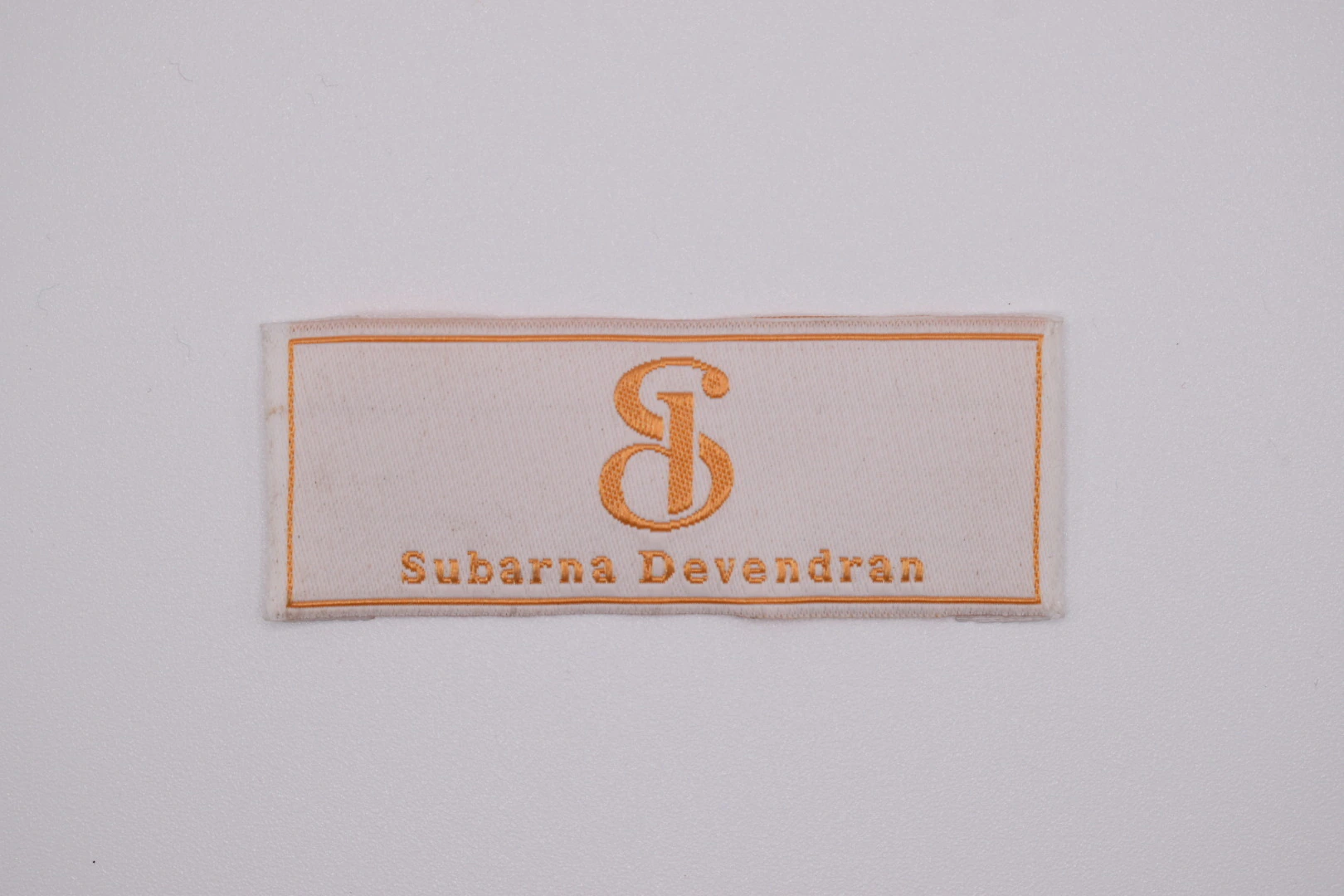 Subarna end-fold woven brand label — front view, custom clothing label sample