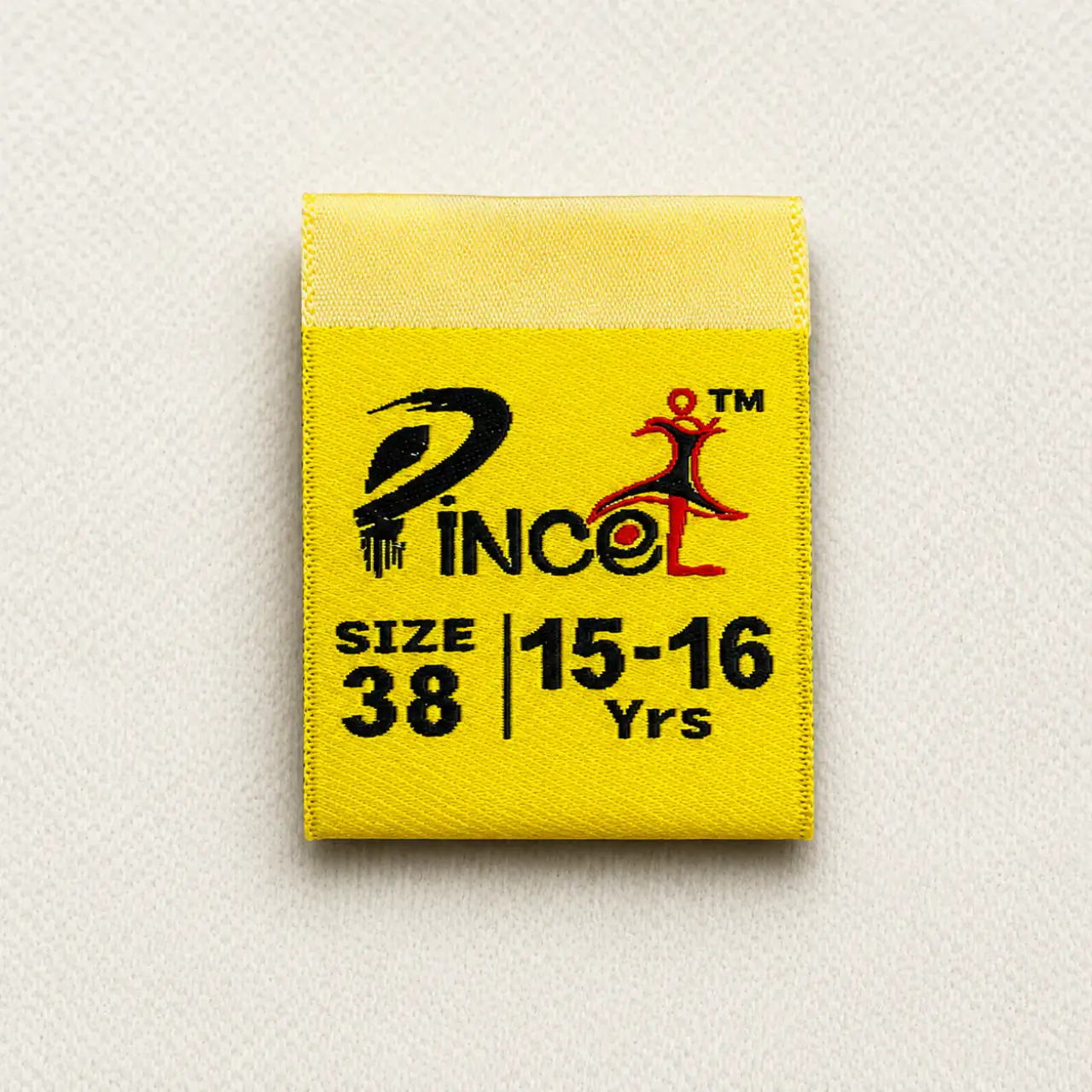 Pincol yellow centre-fold woven size label with brand logo, SIZE 38 and 15-16 Yrs age marker — kids garment woven size label sample