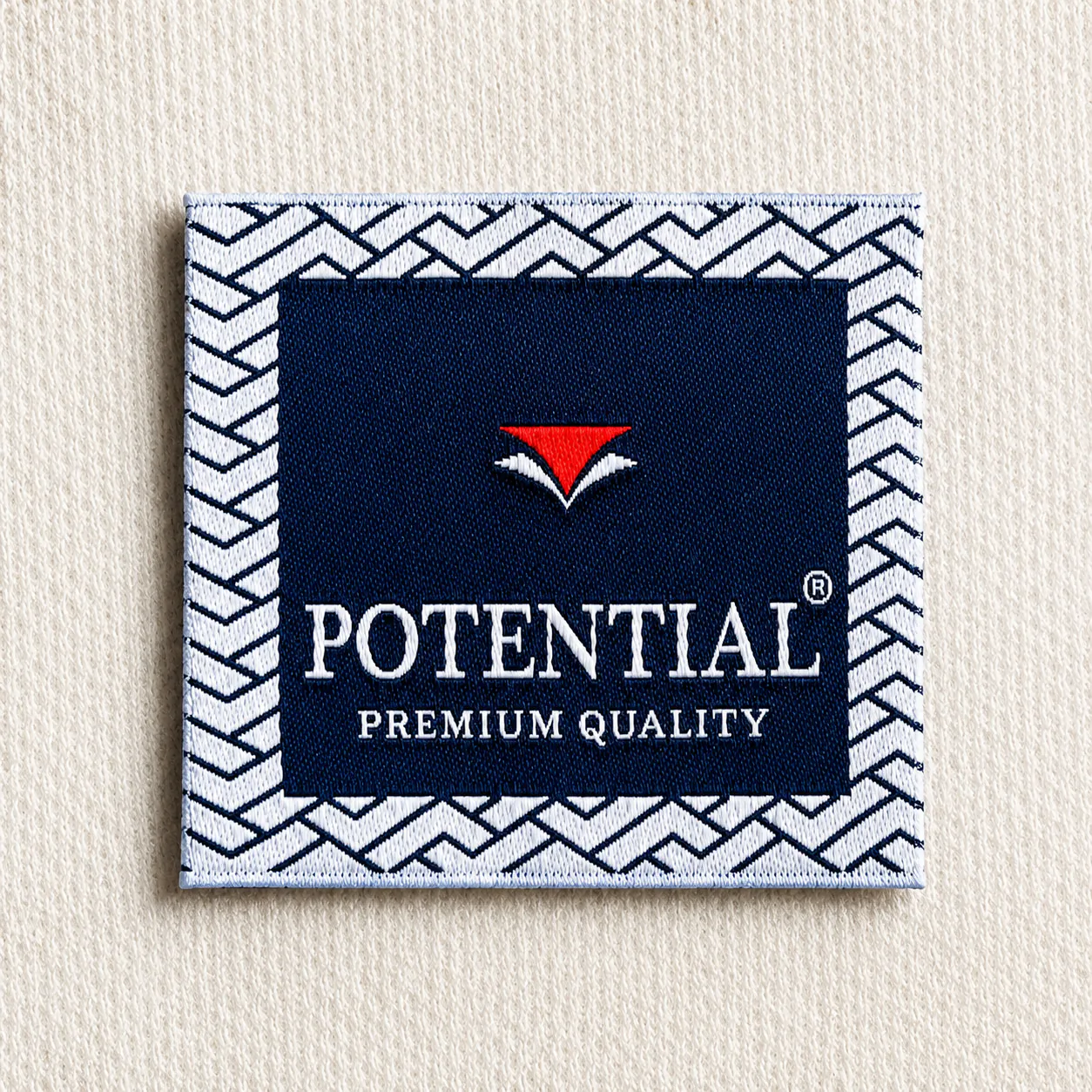 Potential navy woven brand label with red triangular icon, white wordmark, Premium Quality tagline and chevron border — premium menswear woven brand label sample