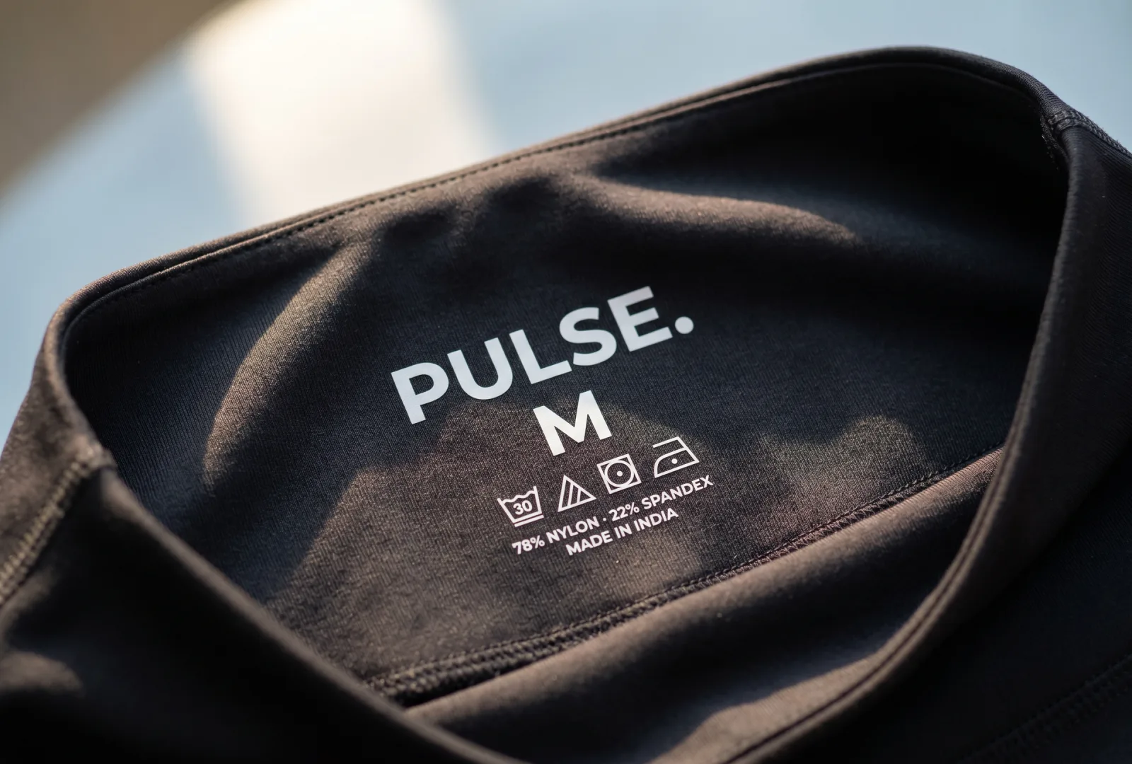 Tagless heat-press transfer printed on the inside of a black activewear top — example of a heat-press label